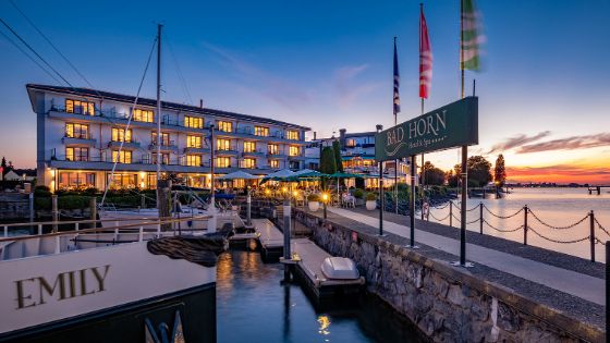 Ein Hotel am See mit beleuchteten Fenstern in der Abenddämmerung. 
