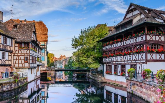Fachwerkhäuser mit Blumenschmuck am Kanal im Viertel La Petite France in Strassburg.